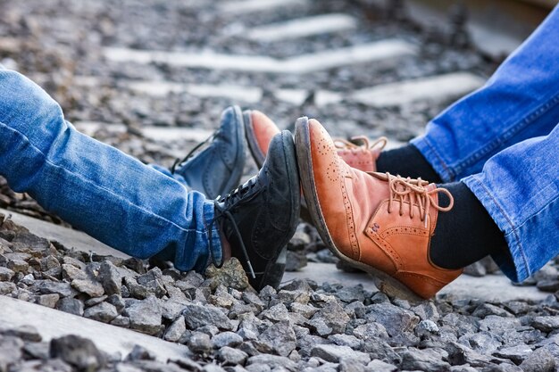 Pieds de chaussures de cowboy père et fils près du chemin de fer