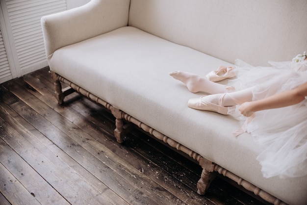 Pieds de danseuse de ballet sur le sol du studio. Danseuse adolescente met copyspace ballerines.