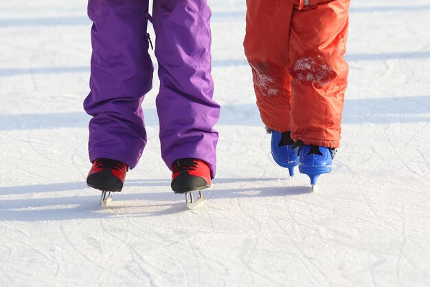 Pieds de différentes personnes patinant sur la patinoire