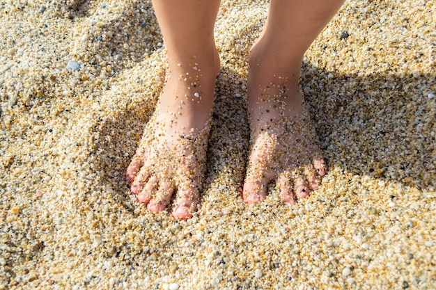 Pieds d'un enfant dans le sable de la plage