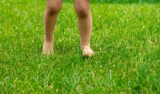 Photo les pieds de l'enfant sur l'herbe focus sélectif kid