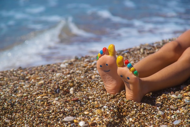 Pieds d'enfant peints avec des peintures sur la mer. Mise au point sélective.