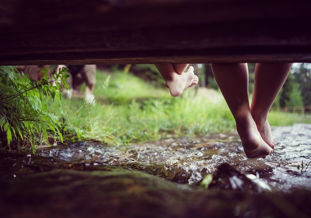Photo pieds d'enfants jouant et s'amusant sur le magnifique ruisseau de montagne