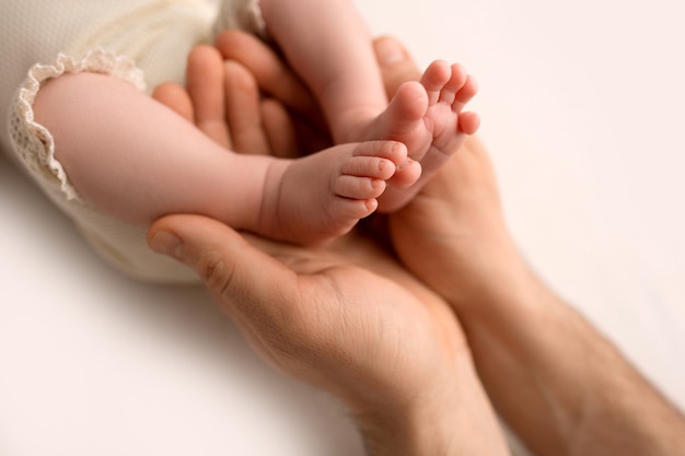 Les pieds des enfants tiennent la main de la mère et du père sur blanc. Mère, père et enfant. Concept de famille heureuse. photo de haute qualité