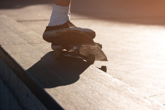 Pieds faisant un tour sur une planche à roulettes.