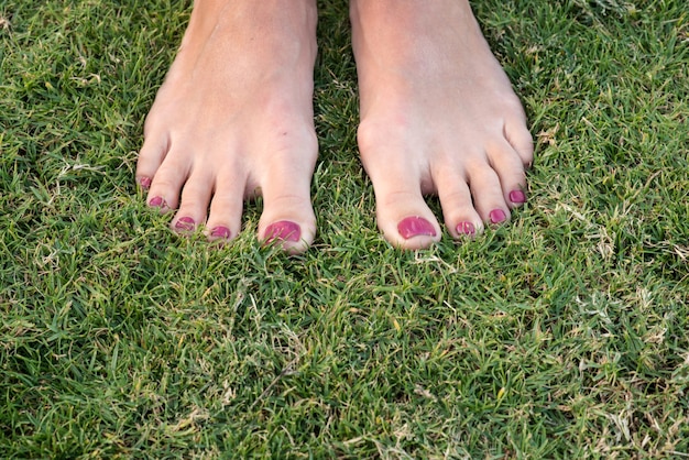 Pieds féminins sur l'herbe libre