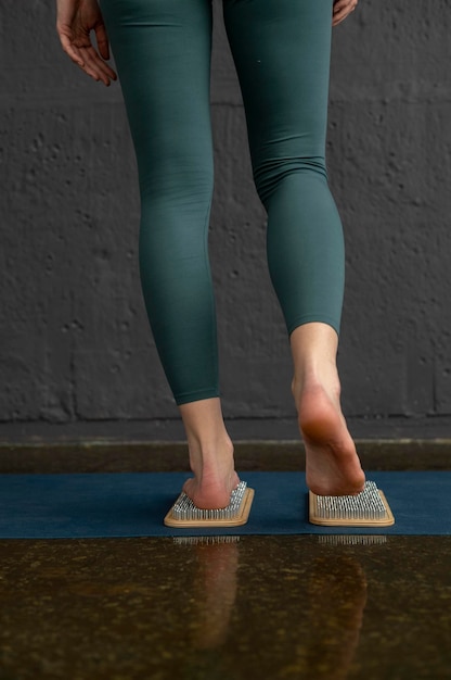 Pieds féminins sur des planches avec des clous Jambes de femme Yogi close up Yoga Practice
