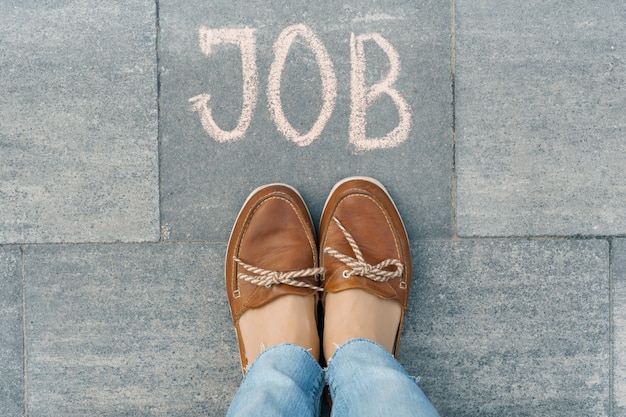 Pieds féminins avec texte écrit sur le trottoir gris