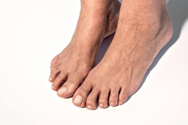 Pieds d'une femme adulte caucasienne sur fond blanc.