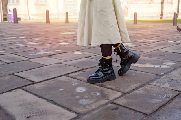 Pieds d'une femme en chaussures noires dans la rue de la ville par temps froid