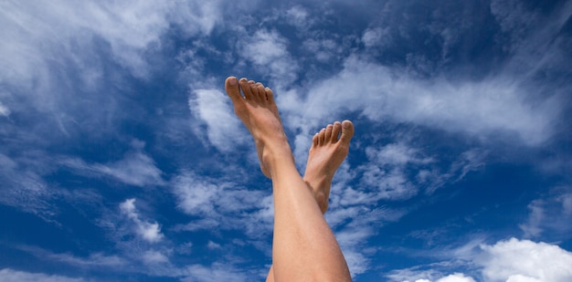 Pieds d'une femme sur ciel bleu