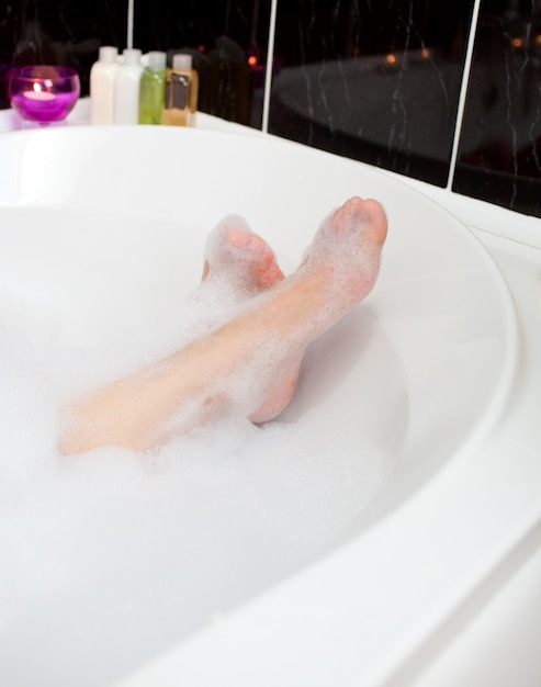 Les pieds de la femme dans un bain moussant