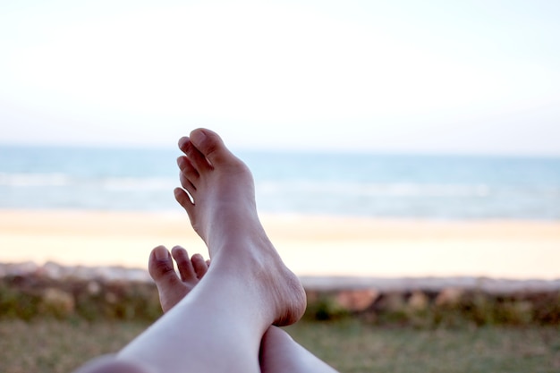 Photo pieds de femme de détente sur le lit de bronzage à la plage.