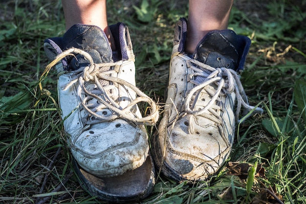 Photo pieds de femme à la maison avec des pantoufles cassées. concept de pauvreté.