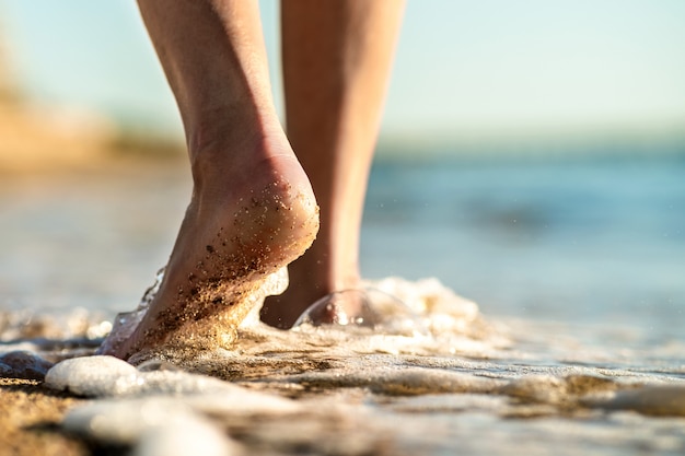 Pieds de femme marchant pieds nus sur la plage de sable