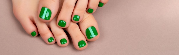 Pieds de femme avec vernis à ongles vert sur fond marron