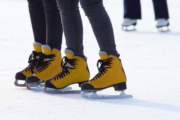 Pieds de femmes patinant sur la patinoire. Sport et divertissement. Repos et vacances d'hiver.