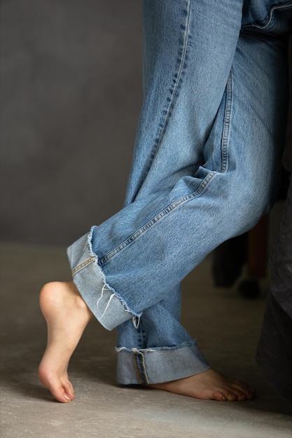 Les pieds des femmes sur le sol sans chaussettes dans des jeans reposent librement