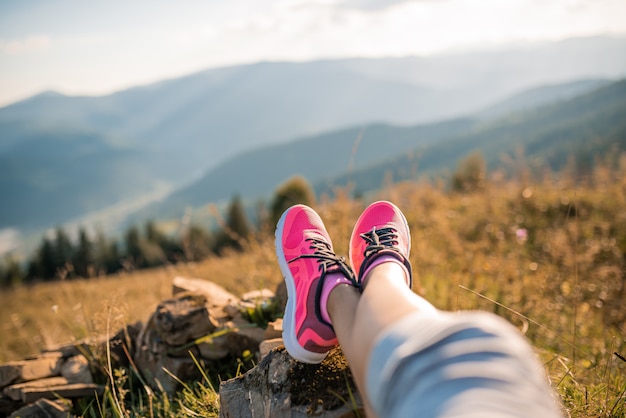 Pieds d'une fille sportive relaxante dans les montagnes