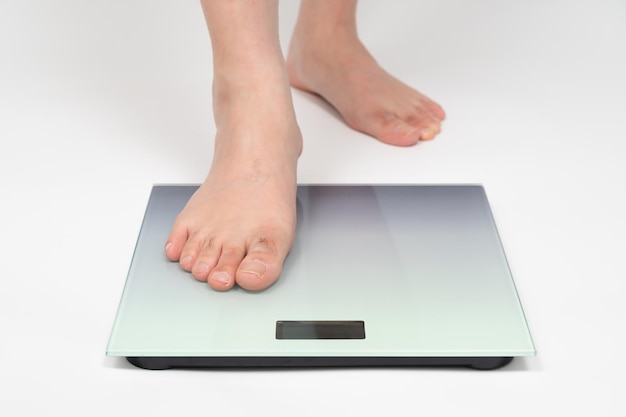 Les pieds de l'homme d'âge moyen asiatique mesurant le poids