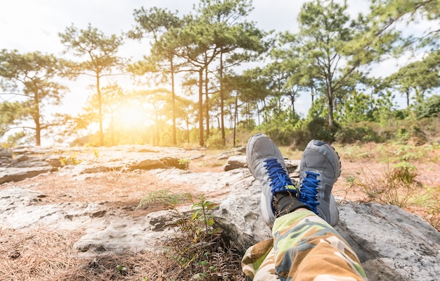 Pieds d&#39;homme en chaussures de sport reposant sur le rocher