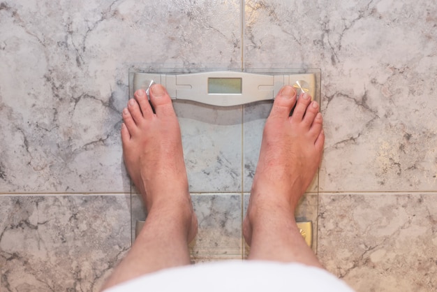 Photo pieds d'homme debout sur une balance