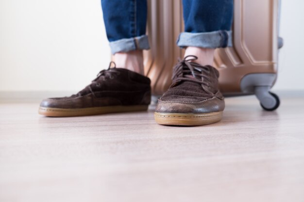 Pieds d'homme debout avec de gros bagages