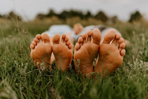 Pieds d'un homme et femme pieds d'un gars et d'une fille sur l'herbe