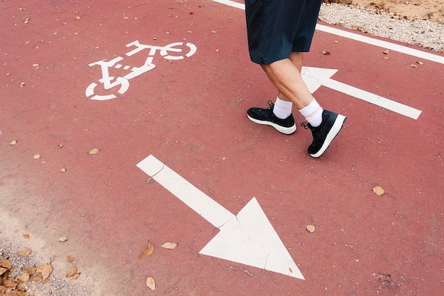 Pieds d'homme marchant sur une piste cyclable