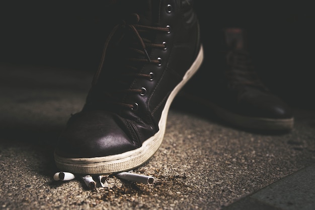 Les pieds d&#39;un homme marchent sur une cigarette. Jours non fumeurs