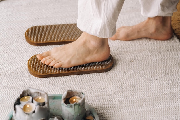 Les pieds de l'homme sont à côté de planches avec des clous Cours de yoga