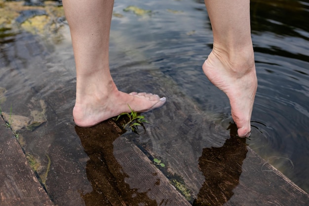 Pieds immergés dans l'eau claire Pieds dans l'eau Selfie des jambes et pieds nus Vacances aux vacances d'été