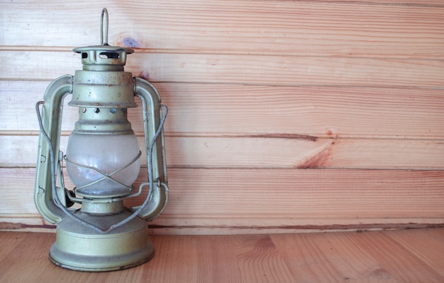 Pieds de lampe au kérosène antiques. Espace pour le texte. Fond en bois rustique. Lampe de camping authentique. Voyages saisonniers