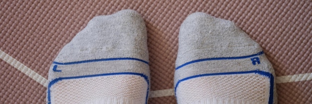 Pieds mâles en chaussettes debout sur un tapis de yoga closeup vue de dessus concept d'entraînement sportif à domicile