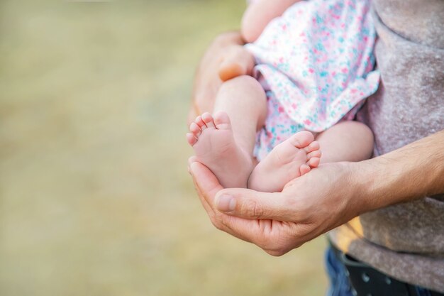 Pieds d'un nouveau-né entre les mains d'un père. Mise au point sélective. Gens.