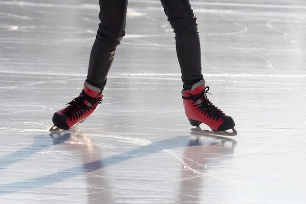 Pieds en patins rouges sur une patinoire. passe-temps et loisirs. sports d'hiver