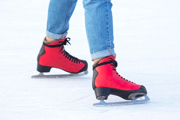Pieds en patins rouges sur une patinoire. passe-temps et loisirs. sports d'hiver
