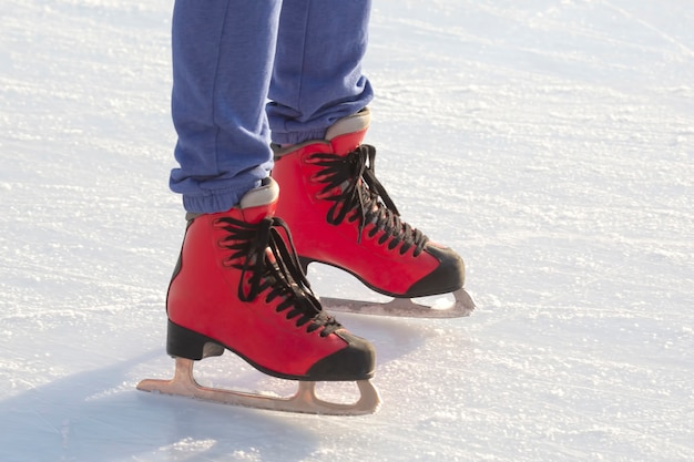 pieds en patins rouges sur la patinoire.