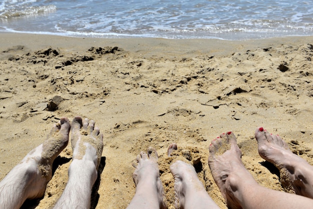 Pieds de personnes allongées sur le sable