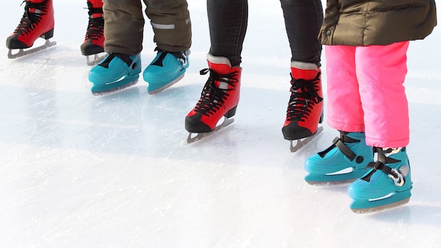 Photo pieds de personnes différentes patinant sur la patinoire. sports, passe-temps et loisirs des personnes actives