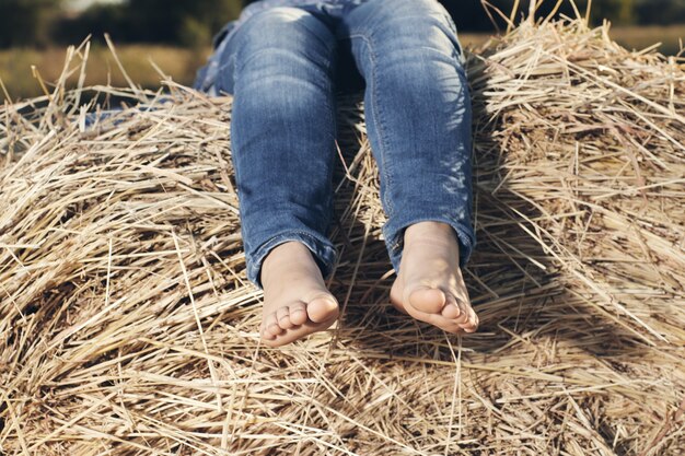 Pieds d'un petit enfant dans le foin.