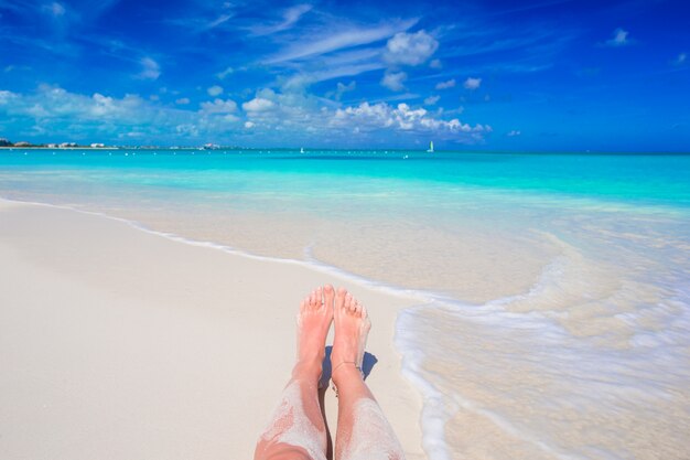 Pieds sur la plage en eau peu profonde