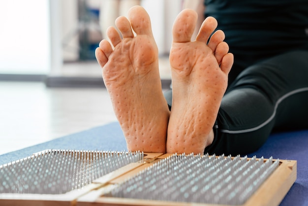 Pieds et planche de bois avec des clous en métal pointus planche de pied de sadhu formation pratique de relaxation de yoga