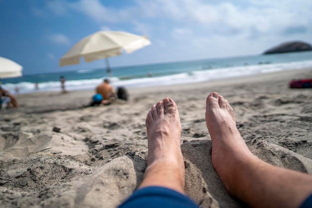 les pieds posés sur le sable de la plage