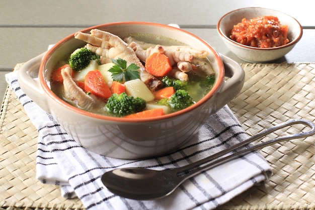 Pieds de poulet Ceker sur soupe claire aux légumes avec pommes de terre, brocoli et carottes