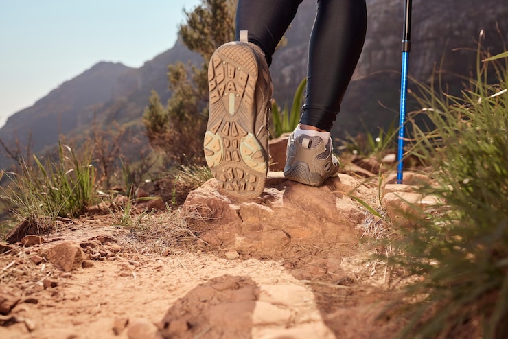 Photo pieds de randonnée et de marche pole sur la direction du sentier et la sécurité avec l'équilibre fitness et l'aventure sur la colline chaussures de personne et bâton sur le défi de montagne ou l'escalade pour l'entraînement sur le sol en argentine