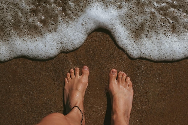 Photo pieds sur le rivage d'une plage avec surfxa mousseux