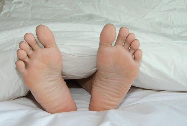 Les pieds sont sur le lit