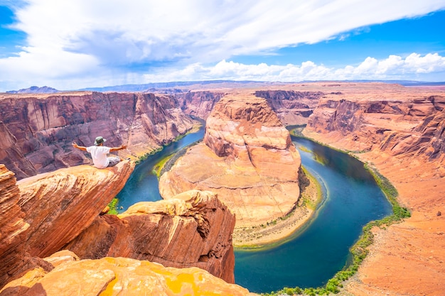 Les pieds sont vus assis à regarder Horseshoe Bend, Arizona. États Unis