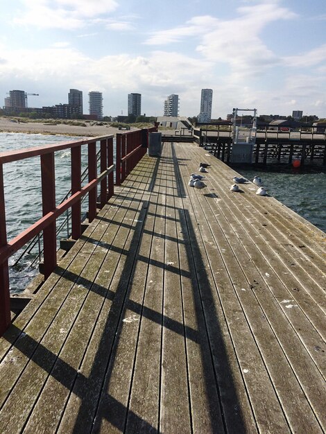 Photo pier au-dessus de la rivière dans la ville contre le ciel